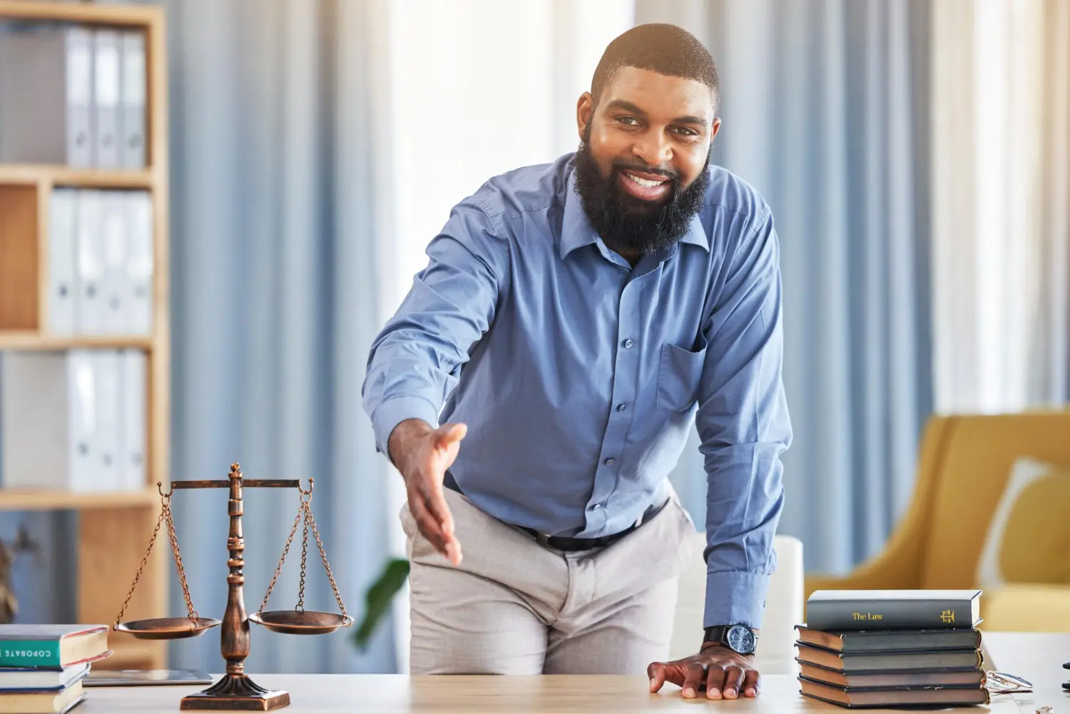 Homem apoiando a mão na mesa, representando um leiloeiro.